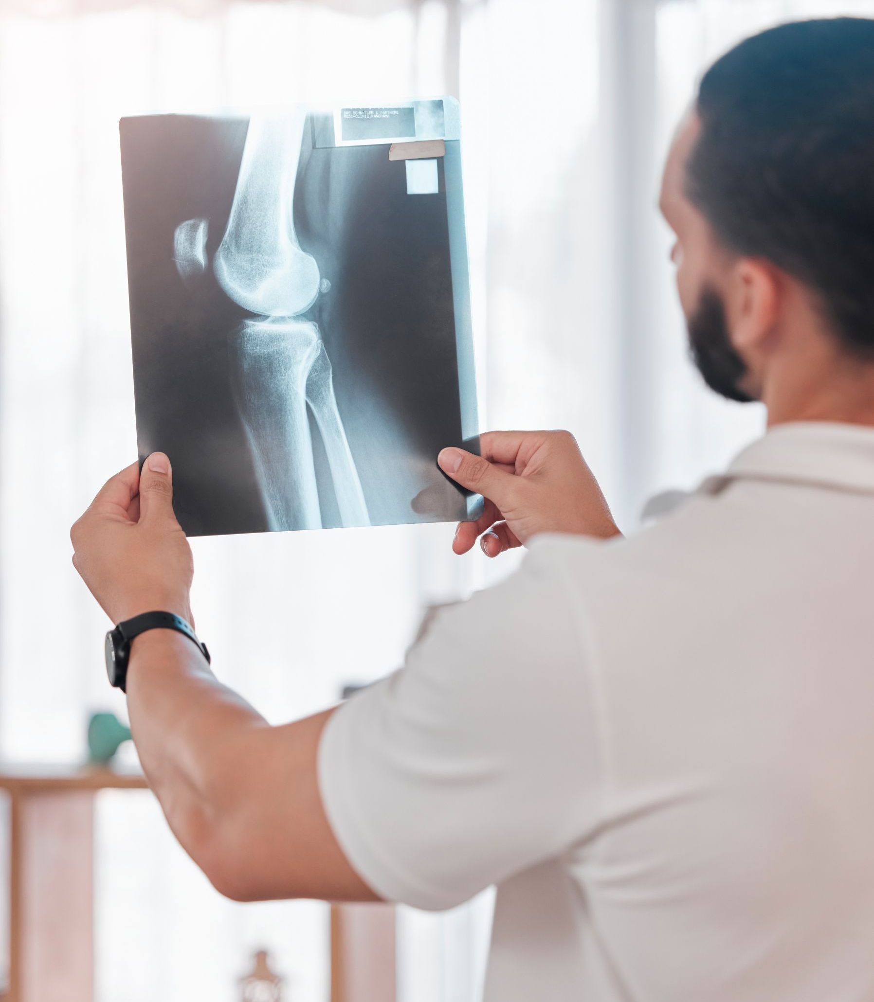 Arzt betrachtet Röntgenbild eines Knies